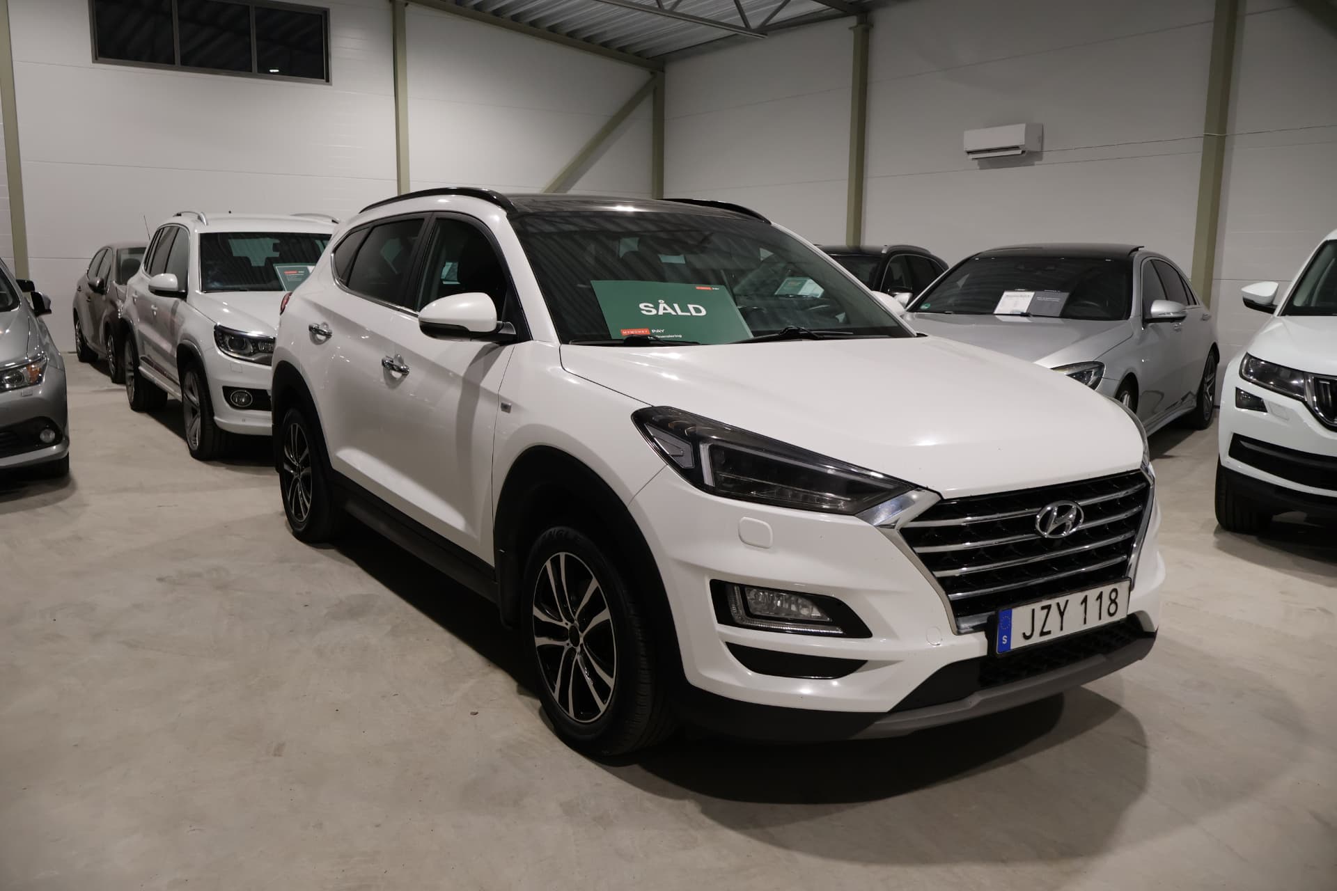 Uppställda bilar med Hyundai Tucson i förgrunden i bilhallen